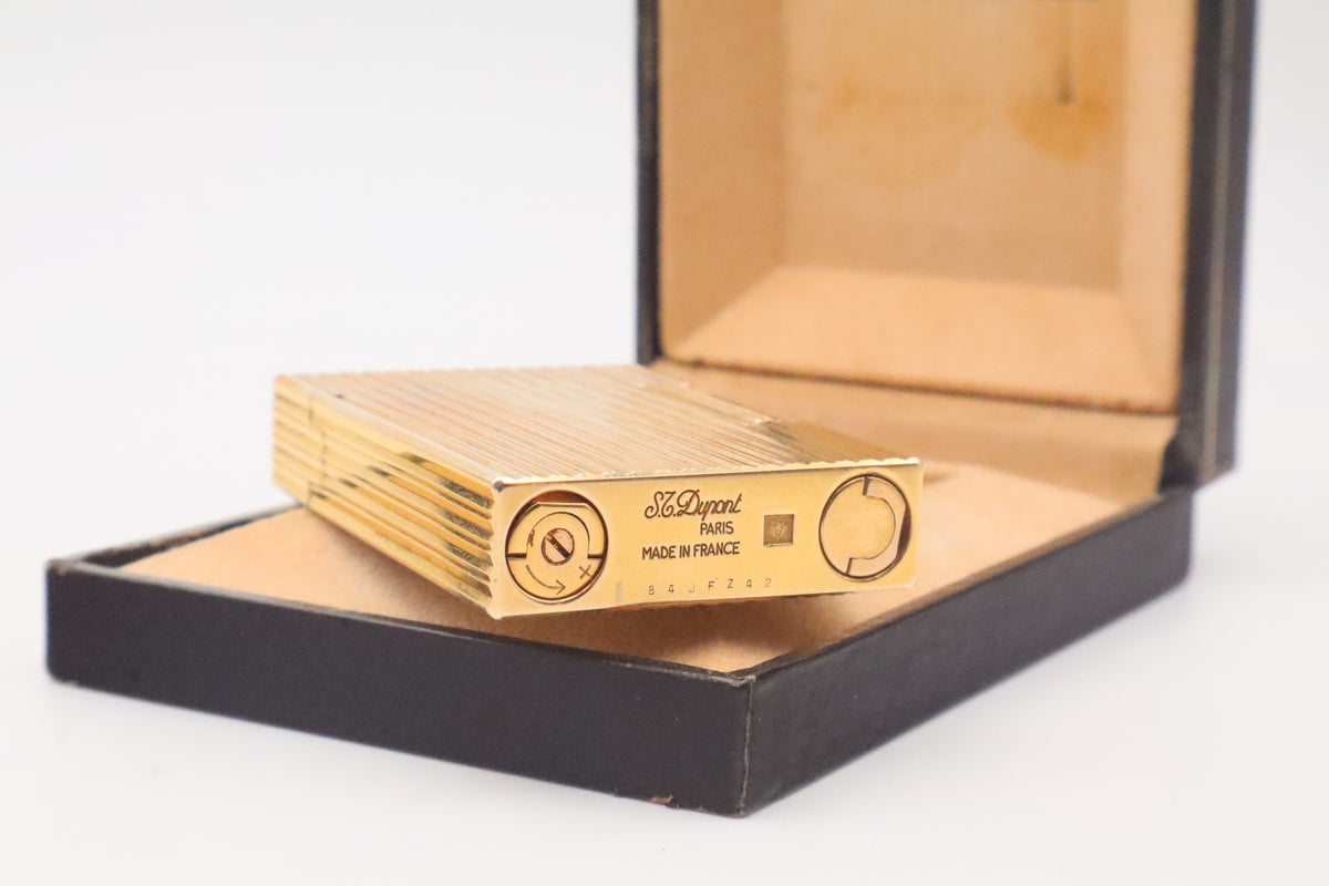 Base of the S.T. Dupont Ligne 2 gold vertical stripes lighter showing the serial number 84 J F Z 42, dating it to 1984